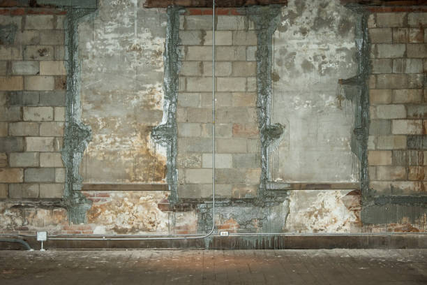 istock Unfinished concrete brick wall with filled windows in an old building that needs to be renovated 1286755177