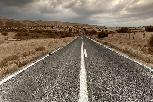 perspective view of blank mountain asphalt road with dramatic sky and clouds