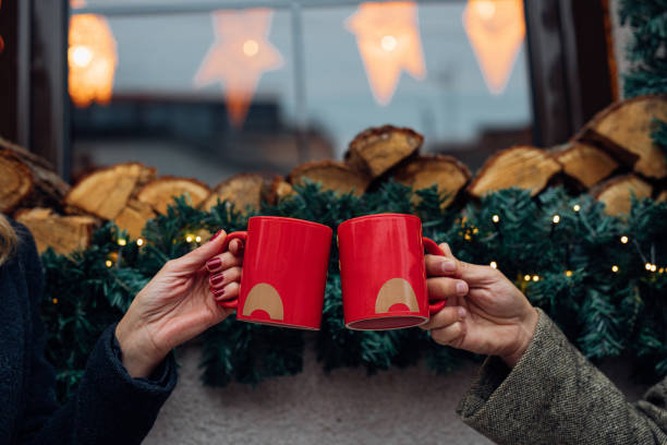 julen är i stan! ett oigenkännligt lyckligt par roar sig dricka glögg i en utomhus cafe, en närmre - julfika bildbanksfoton och bilder