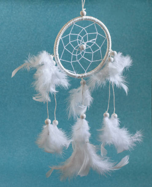 istock White beautiful magic wheel Dreamcatcher with feathers on the blue background. Ethnic amulet, heritage of native american and modern interior decoration. 1286764603