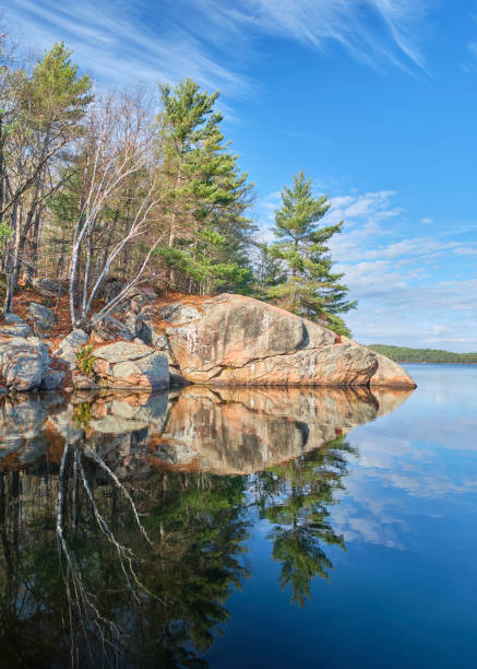 istock Granite Rock and Pine Trees Reflecting in Lake 1286765387