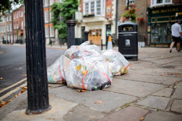 istock Plastic Bags of Trash Abandoned on the Sidewalk Next to a Lamppost 1286766582