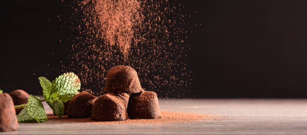 istock Chocolate truffles with mint leaves on wooden table dark background 1286767481