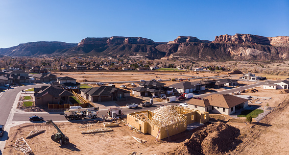 High Priced Neighborhood with new homes under construction in the Southwest USA town of Fruita Colorado with the Beautiful Colorado National Monument in the Background on a sunny afternoon