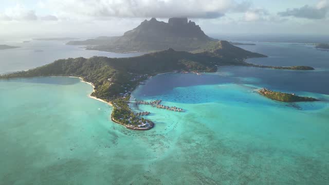 Aerial view Tahiti drone 4k. Bora Bora island, turquoise crystal clear water of scenic blue lagoon, over water bungalows