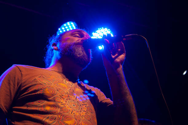 istock Concentrated man singing for audience uses microphone illuminated by blue light nightlife in Mexico city 1286787580