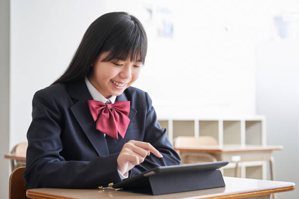 a japanese junior high school girl uses a tablet in the classroom - japanese girl imagens e fotografias de stock