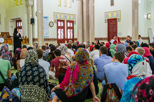 Non-Muslim guests listening a lecture from a Muslim female teacher inside of Jumeirah Mosque, the only mosque in Dubai which is open to the public and receiving non-Muslim guests