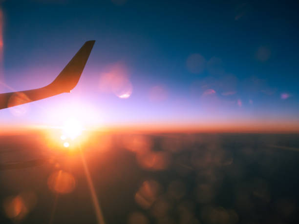 Winglet and setting sun seen from airplane window stock photo