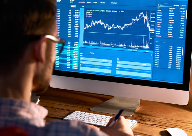 istock Business man trader broker looking at pc computer screen, investor manager analyzing financial chart, exchange trading online investment data crypto currency stock market graph, over shoulder view. 1286802131