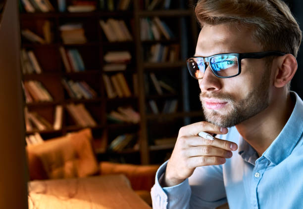 istock Serious focused businessman wearing computer glasses looking at pc screen with computer reflection using internet, watching webinar training, working online by video conference, close up face view. 1286802146