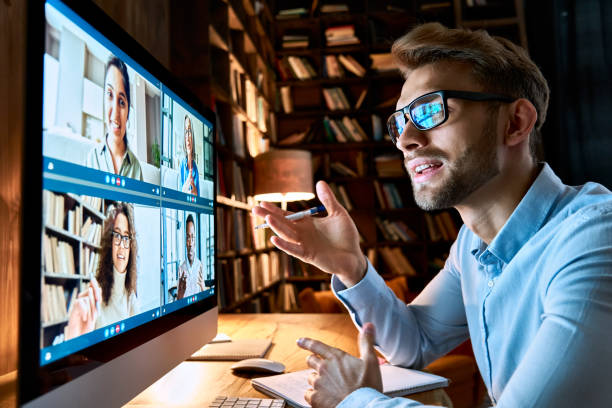Young business man talking with diverse colleagues in virtual video conference group chat using computer at home office. Online professional videoconference communication, social distance work concept joven hombre de negocios hablando con diversos colegas en el grupo de videoconferencia virtual chat usando la computadora en la oficina en casa. comunicación de videoconferencia profesional en línea, concepto de trabajo a distancia social
