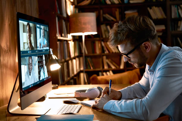istock Young business man video conference calling using computer social distance working from home office. Remote male professional videoconferencing by virtual team online web meeting group chat. 1286802151