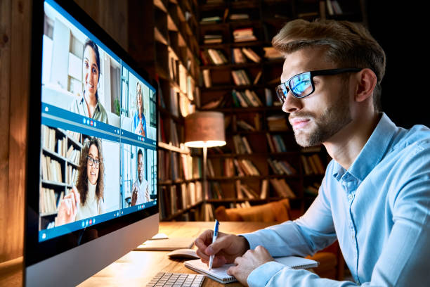 istock Business man having virtual team meeting on video conference call using computer. Social distance employee working from home office talking to diverse colleagues in remote videoconference online chat. 1286802161
