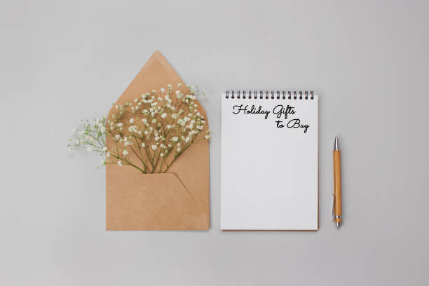 istock Beautiful holiday flat lay composition with Christmas presents list on light grey background with copyspace. Holiday, birthday or christmas presents and gifts concept 1286804850