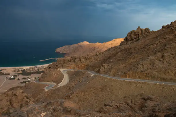 Dark clouds forming on the coastline of Oman on the top of a rocky mountains