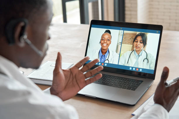 istock Multicultural doctors team conferencing in video call chat discussing health care learning online during web seminar. Group medical webinar training, healthcare elearning videoconference concept. 1286810741