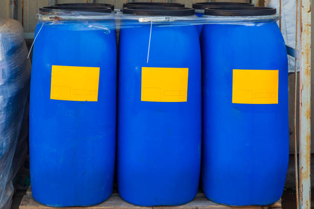 istock Three scratched blue packed barrels with orange labels 1286811938