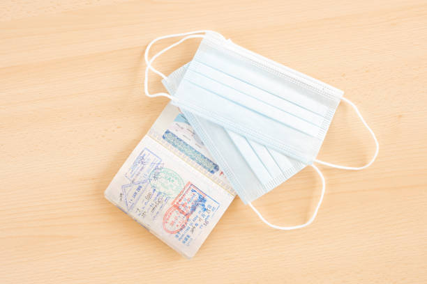 istock Travel concept, two face masks are arranged on a passport. 1286811994