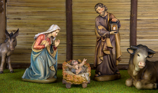Christmas crib with statuettes of Mary, Joseph and baby Jesus in the barn