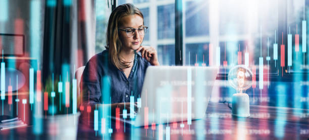 Businesswoman working at modern office.Technical price graph and indicator, red and green candlestick chart and stock trading computer screen background. Double exposure. Trader analyzing data Young woman working at modern office.Technical price graph and indicator, red and green candlestick chart and stock trading computer screen background. Double exposure. Trader analyzing data trading technology finance trader stock pictures, royalty-free photos & images