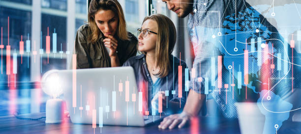 istock Group of business people working at modern office.Technical price graph and indicator, red and blue candlestick chart and stock trading computer screen background. Double exposure. Traders at work 1286815176