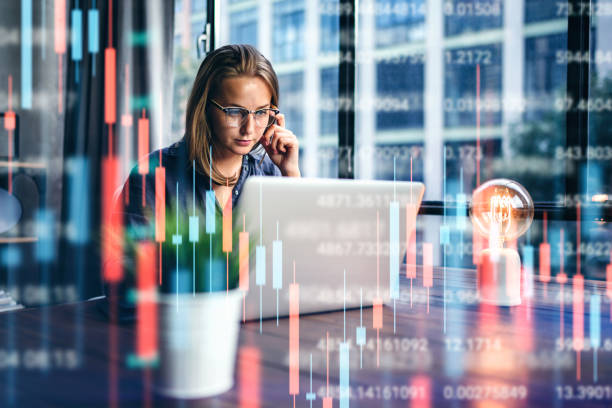istock Businesswoman working at modern office.Technical price graph and indicator, red and green candlestick chart and stock trading computer screen background. Double exposure. Trader analyzing data 1286815180