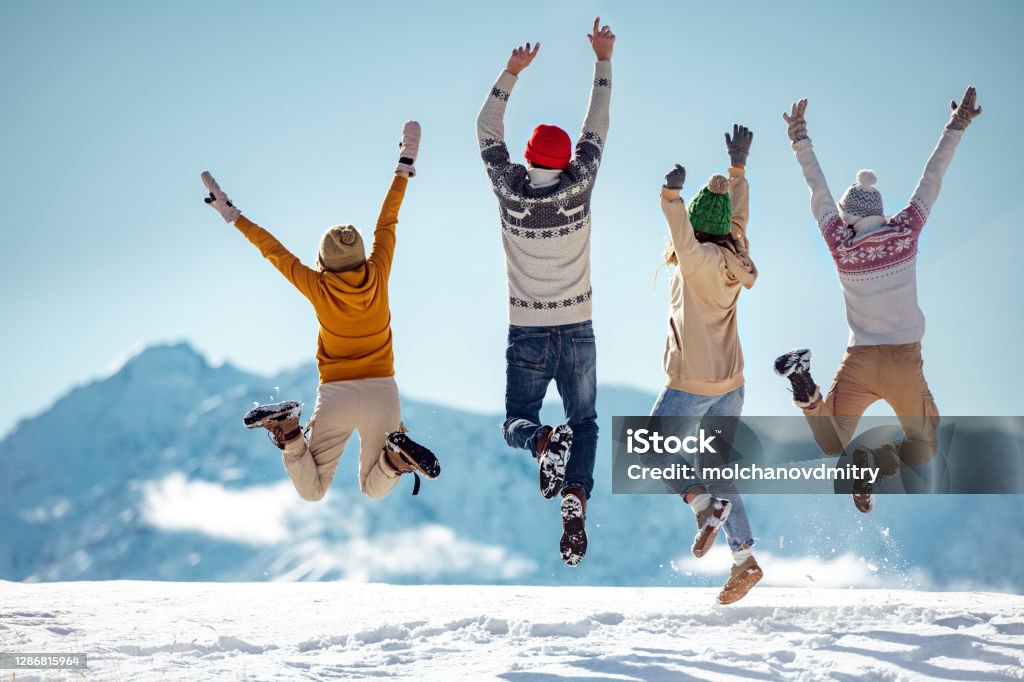 Friends celebrates beginning of winter in mountains Friends celebrates beginning of winter in mountains, jumps and having fun Winter Stock Photo