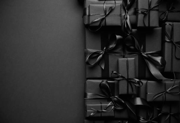 Stos różnej wielkości czarne prezenty w pudełku umieszczone na stosie. Koncepcja Świąt Bożego Narodzenia – zdjęcie