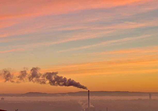 Industrial chimney smoke in sunrise Industrial chimney smoke air pollution in sunrise. Stuttgart, Germany carbon neutrality photos stock pictures, royalty-free photos & images