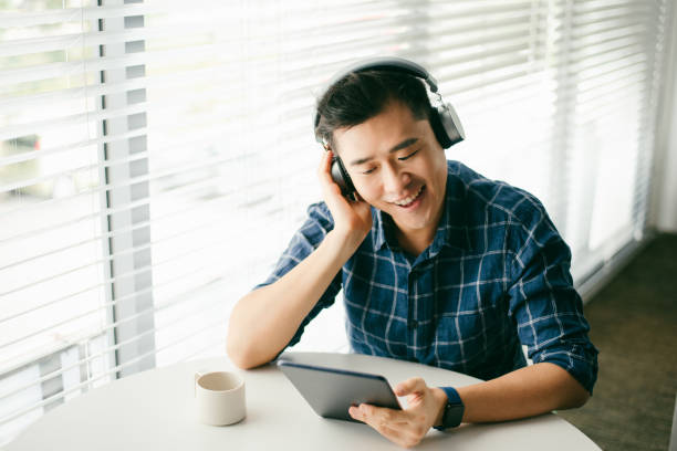 istock An Asian man using wireless headphones with a digital tablet in living room 1286820681