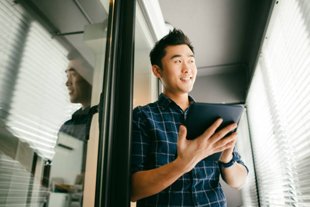 istock An Asian man relaxing by the home window and typing a message on his digital tablet 1286820684