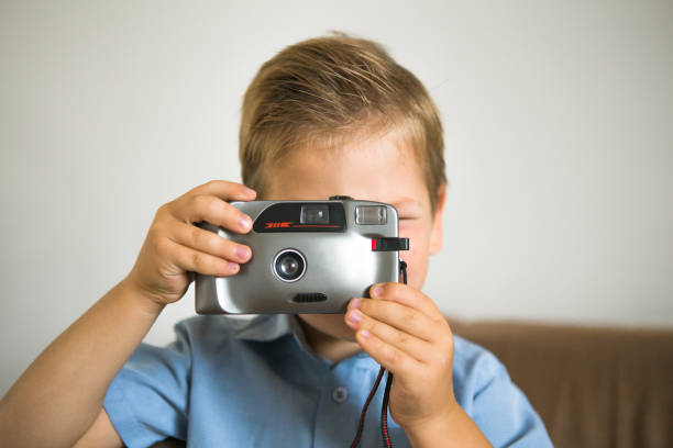 istock Boy photographer with vintage camera. Boy using vintage camera lifestyle. 1286822333