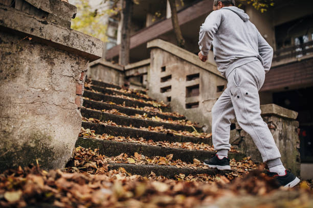 An older man exercises on the steps with autumn leaves