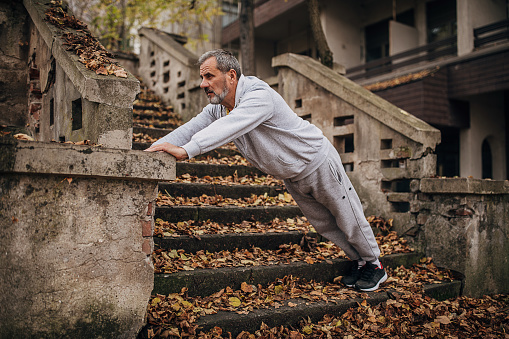 An older man exercises on the steps