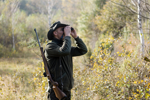 Hunter Looking Through Binoculars in the forest