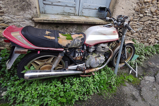 abandoned motorbike with moss on saddle