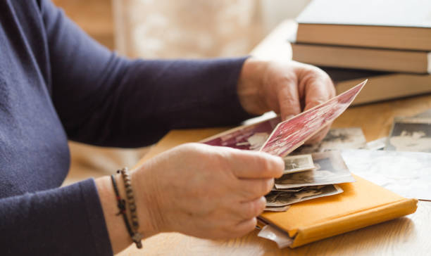 istock Memory. Eldery woman looking vintage photos. 1286826862