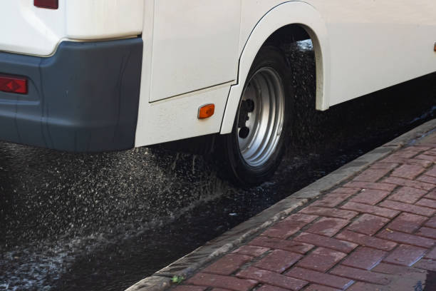 istock Water spray from under the wheels of a white car 1286827240