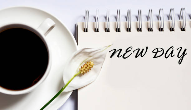 istock NEW DAY , planning concept. notebook with text on white background with coffee 1286827965