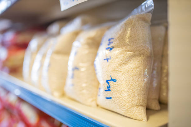 Picture of Rice Packed in Plastic Bags and on a Shelf Ready for Sale with prices written on the bags