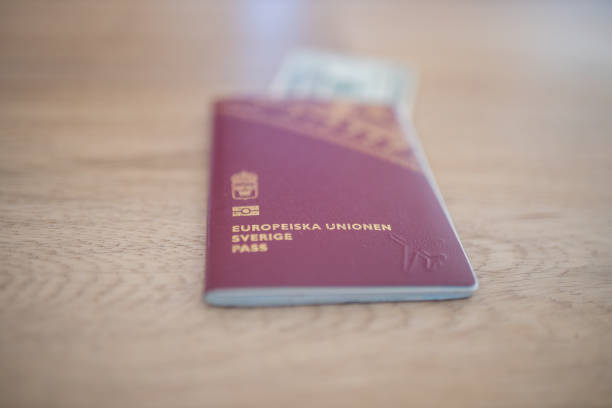 istock Sweden Passport with a Blurry Twenty Thai Baht Bill Partially Inside 1286831073
