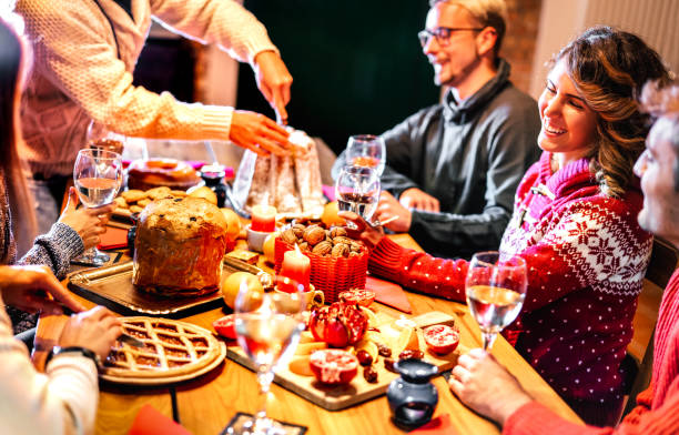 glückliche junge freunde verkostung weihnachten süßes essen spaß zu hause abendessen party - winter-freundschaftskonzept mit tausendjährigen menschen genießen silvester abendessen essen zusammen - warm filter - fruitcake christmas christmas cake food stock-fotos und bilder