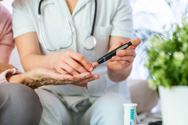 Nurse measuring blood sugar of senior woman at home. Young nurse measuring blood sugar of elderly woman at home. Doctor checking elderly woman's blood sugar - diabetes and glicemia concept Nurse measuring blood sugar of senior woman at home. Young nurse measuring blood sugar of elderly woman at home. Doctor checking elderly woman's blood sugar - diabetes and glicemia concept hyperglycemia stock pictures, royalty-free photos & images