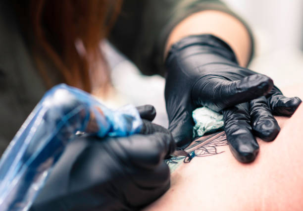 istock Female tattoo artist making a tattoo 1286833235