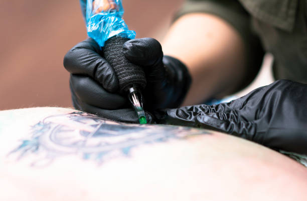 Female tattoo artist making a tattoo Close up tattooing process, Woman master getting tattoo in studio tattooing stock pictures, royalty-free photos & images