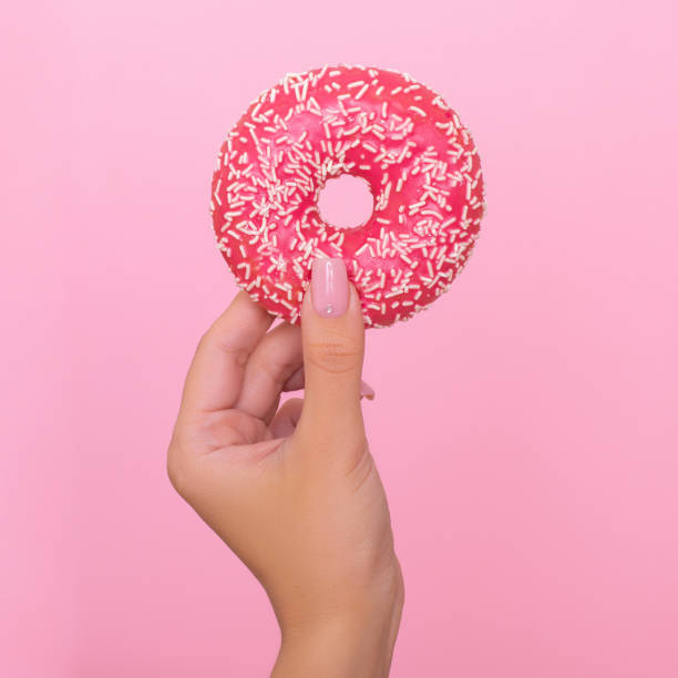 istock Female hand holding donut 1286834872