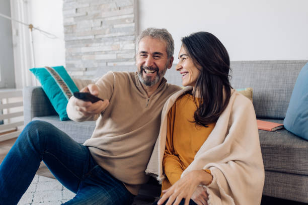 Mature couple watching TV at home