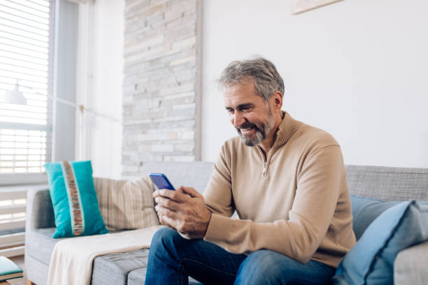 istock Mature man relaxing on the sofa and shopping online 1286835084