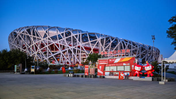 Beijing, China - 25th September 2013: The iconic steel lattice of Beijing's National Stadium, or Bird's Nest, reflecting in the tranquil waters of Olympic Park lake in the heart of China's vibrant capital city. Composite panoramic image created from six contemporaneous sequential photographs.